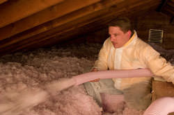 Blow-in fiberglass insulation is installed